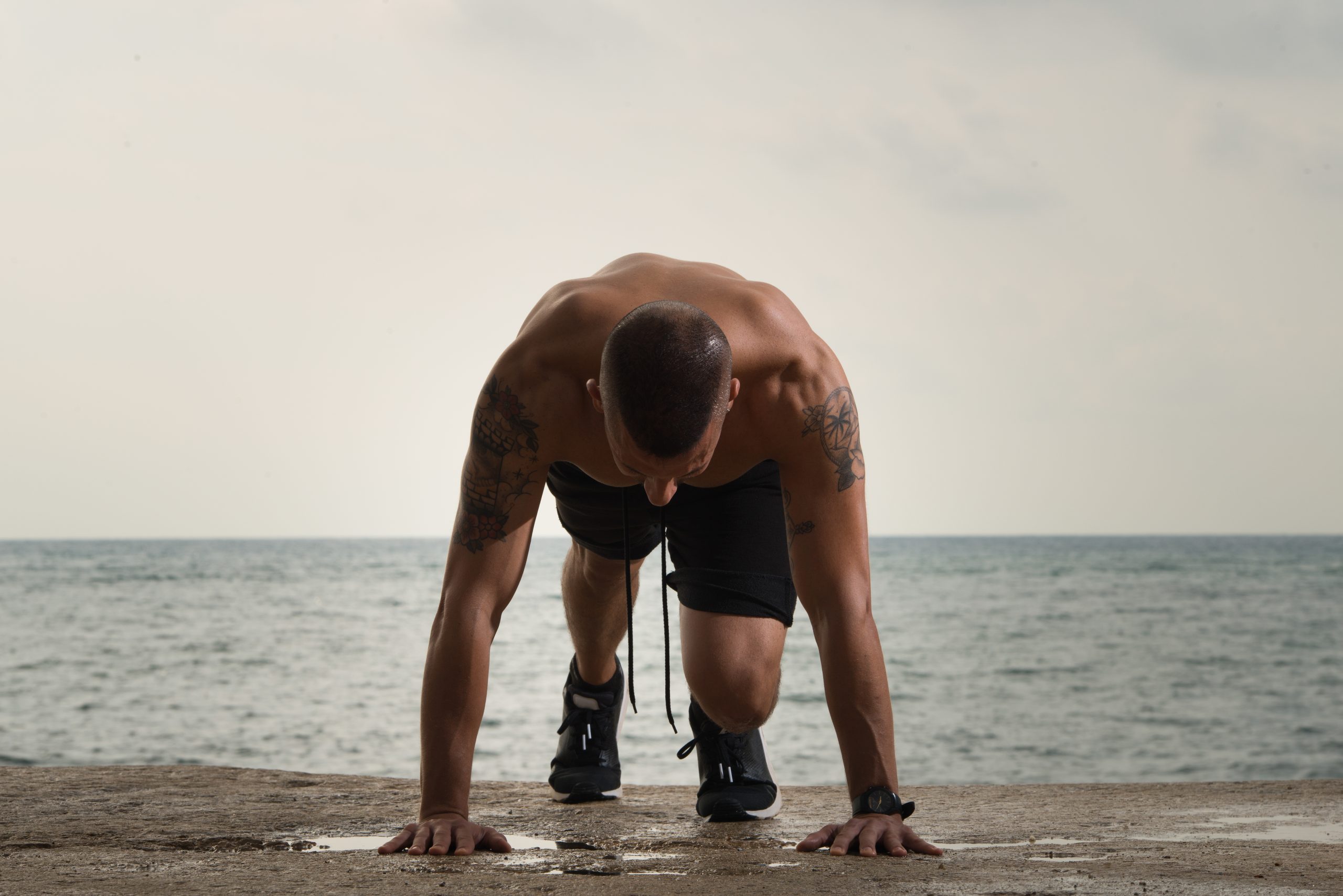 Big muscled guy doing push-ups on ground